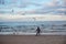 Running child and many seagulls at a beach on a cloudy day in Swinoujscie, Poland.