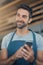 Running a coffee shop with smart apps. a young man using a mobile phone while working at a coffee shop.