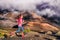 Running fit runner athlete woman training cardio exercising outdoors in mountains landscape in high altitude with clouds and fog.