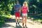 Running fitness couple of runners doing sport on road outdoor. Active living man and woman jogging training cardio