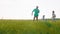 Running in front of the camera charismatic little boy with his dad and pretty small dog background young female with