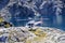 Running helicopter landed on rocks - lake in background on Mt. Kidd