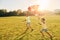 Running with kite. Two african american kids have fun in the field at summer daytime together