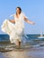 Running laughing bride on the sea