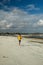 Running man jogging on beach. Indonesian teenager in shorts and a yellow T-shirt running along the beach. Young athlete trains by