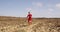 Running man - male runner on desert road running fast in red running clothing