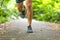 Running man runner athlete workout jogging outdoors on city park path with running shoes closeup of feet