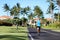 Running man sports fitness athlete runner jogging on residential road in tropical city. Summer workout person training