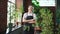 Running of own business. Young woman florist wearing apron in botanical store with green plants. Happy small business