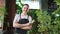 Running of own business. Young woman florist wearing apron in botanical store with green plants. Happy small business