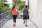 Running pair exercising outside in the city in an urban living active sport photo, with buildings in the background