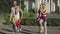 Running in place of group of confident fit 1980s people in sunlight outdoors. Positive Caucasian retro man and women