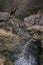 A running river through the rocks of the mountain in autumn.