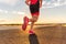 Running shoes on male triathlete runner - closeup of feet running on road. Man jogging outside exercising training for