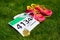 Running shoes, marathon race bib (number) and finisher medal on grass background,