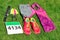 Running shoes, marathon race bib number, runner gear and energy gels on grass background, sport competition