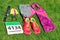 Running shoes, marathon race bib number, runner gear and energy gels on grass background, sport competition, fitness