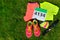 Running shoes, marathon race bib (number), runners gear and energy gels on grass background