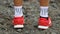 Running shoes on trail running path. Close up of male running shoes outdoors. Man wearing red shoes and white sport