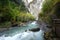 Running stream from Cascada de Sorrosal Sorrosal waterfall with yellow autumn trees in Broto