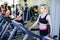 Running on treadmill in gym or fitness club - group of women doing cardio exercises.