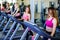 Running on treadmill in gym or fitness club - group of women doing cardio exercises.