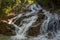 Running water through rocks in tropical waterfall in rainforest