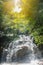 Running water of tropical waterfall in rainforest under sun light