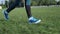 Running. Woman jogging on green grass at stadium. Female wearing training shoes running outdoor. Marathon runner jogging on trail.