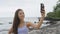 Running woman taking selfie on smart phone beach