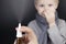 A runny nose is treated with a medicine from a nasal spray. Nasal drops on a black background. Concept for treating a baby cold or