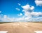 Runway, airstrip in the airport terminal with marking on blue sky with clouds background. Travel aviation concept...