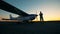 Runway landing with a male aviator and his small aircraft during sunset