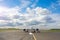 Runway with passenger airplane ready for take off, airstrip with marking on blue sky with clouds background. Travel aviation