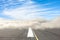 Runway road wrapped in dense low fog, clear blue sky from above. The concept of bad weather at the airport, the delay in the