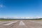 The runway of a rural small airfield against a blue sky