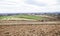 Rural agricultural landscape, tractor ploughing a field