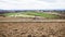 Rural agricultural landscape, tractor ploughing a field