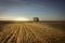 Rural agriculture field at sunrise with people going into distance in forward direction sunrise sky horizon countryside landscape