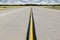 Rural Airport Runway With Bright Yellow Line and Golden Wheatfield