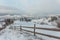 Rural alpine winter landscape with fence and path