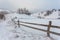 Rural alpine winter landscape with fence and path