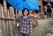 Rural Asian girl, about 8 years , hiding blue umbrella and laugh