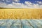 Rural background, template - horizontal surface of the boards on the background of wheat field with the sky