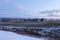 Rural blue hour morning winter landscape with small village and snowy fields along the route 281