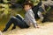 Rural boy sitting by riverbank