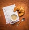 Rural breakfast with cup of coffee and croissants on wooden background