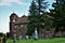 Rural brick church with dual bell towers surrounded by a graveyard