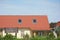 Rural cottage with red metal roof and attic skylight windows