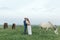 Rural couple on a green meadow communicates with animals. Pregnant wife. Therapy and relaxation for pregnant women